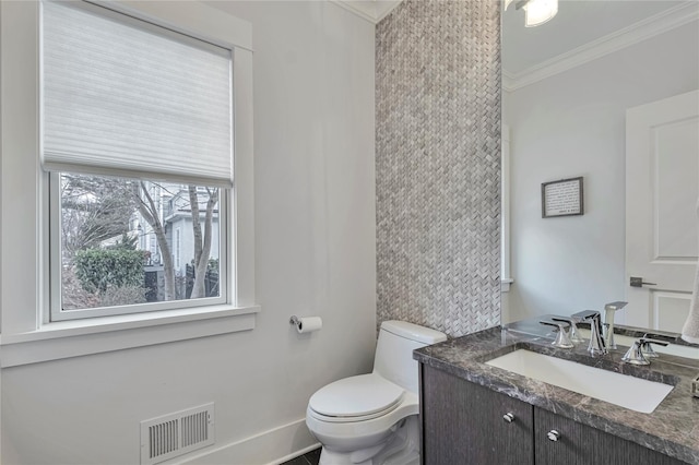 bathroom with ornamental molding, toilet, and vanity