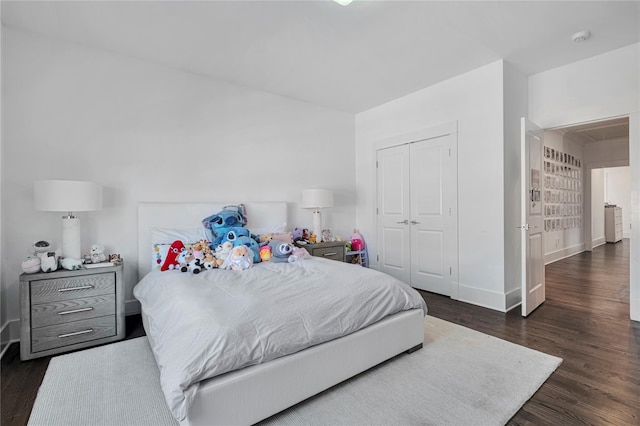 bedroom with dark wood-type flooring and a closet