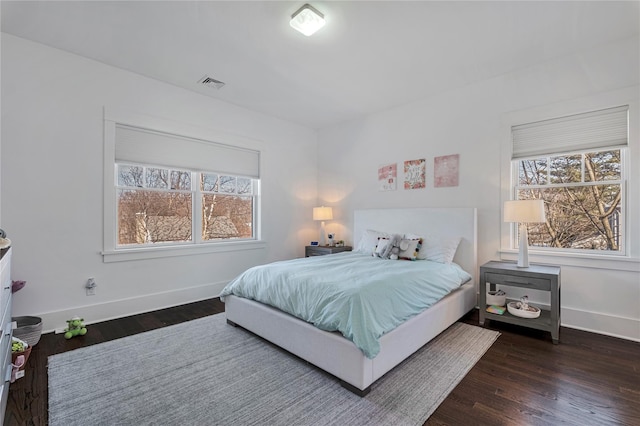 bedroom with dark hardwood / wood-style flooring and multiple windows