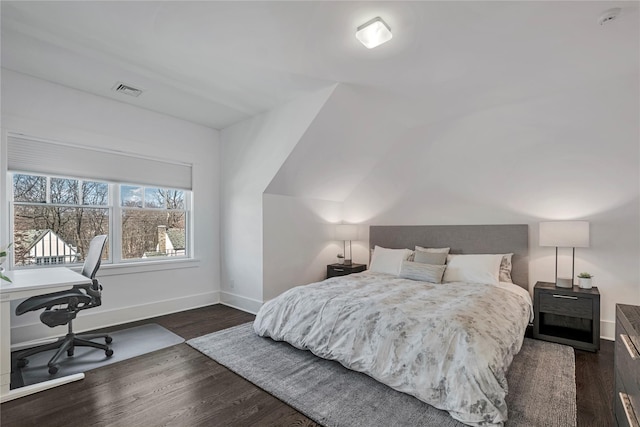 bedroom with lofted ceiling and dark hardwood / wood-style floors