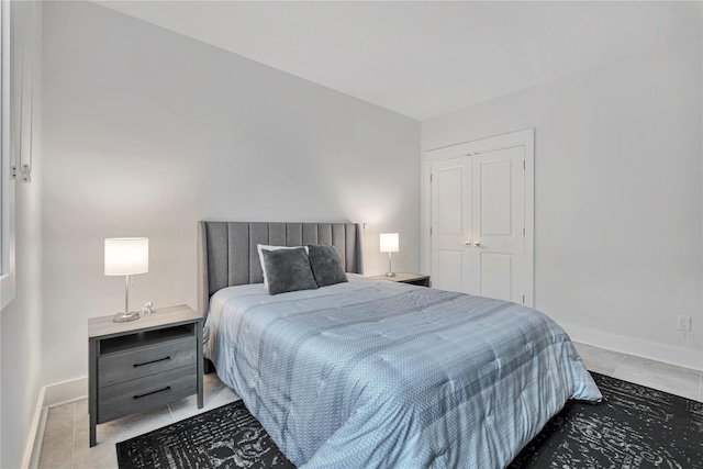 bedroom with tile patterned flooring and a closet