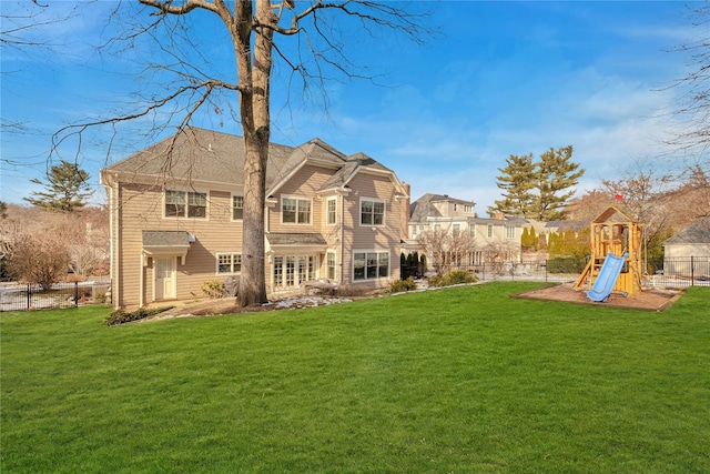 back of property featuring a playground and a yard