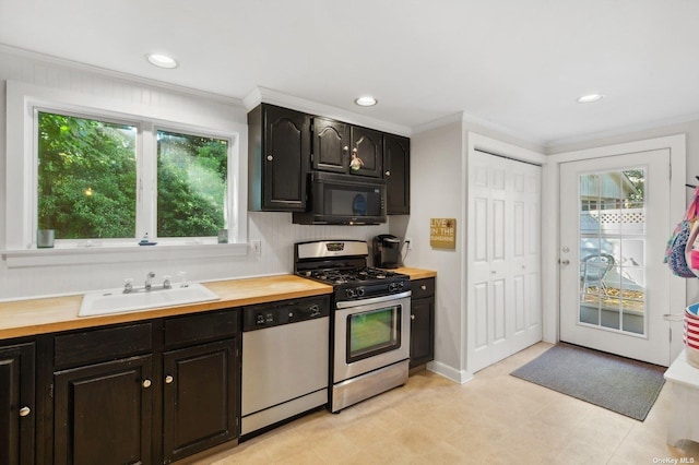 kitchen with ornamental molding, appliances with stainless steel finishes, sink, and butcher block countertops