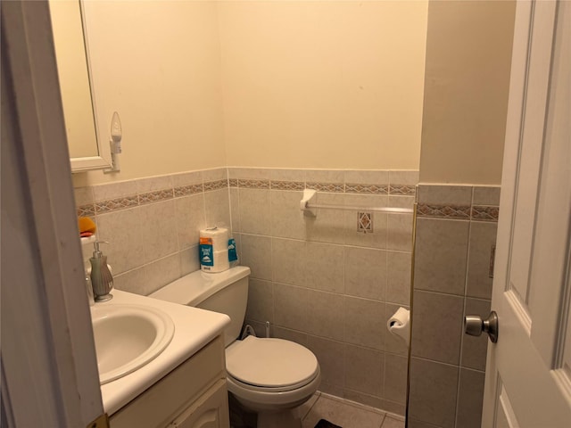 bathroom with vanity, toilet, tile patterned flooring, and tile walls