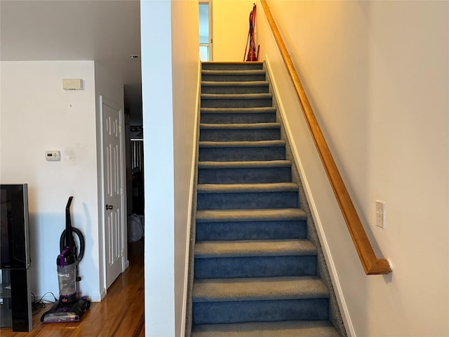 stairs featuring hardwood / wood-style floors