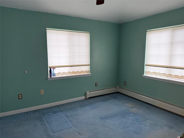 carpeted empty room featuring ceiling fan, a baseboard radiator, and a healthy amount of sunlight