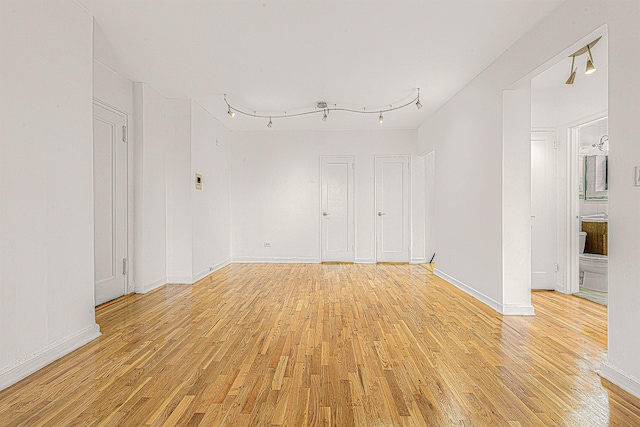 unfurnished room featuring rail lighting and light wood-type flooring