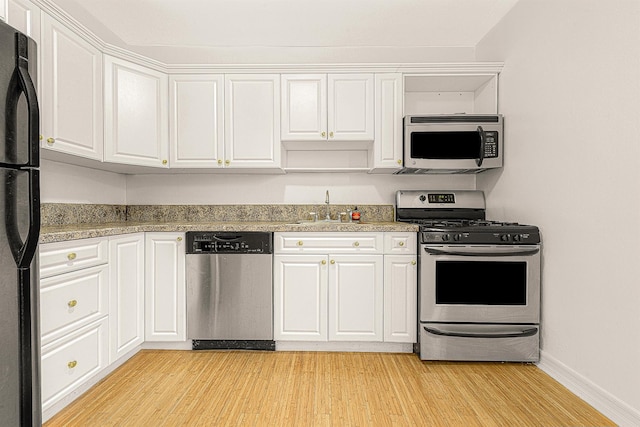 kitchen with white cabinetry, sink, light hardwood / wood-style flooring, and appliances with stainless steel finishes