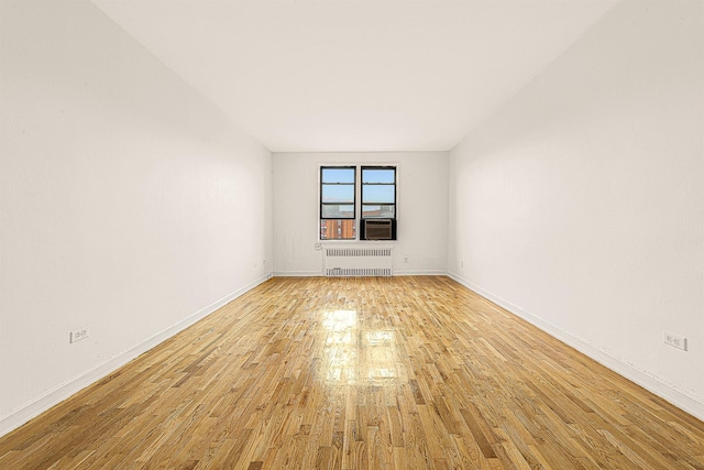 empty room with radiator and light wood-type flooring