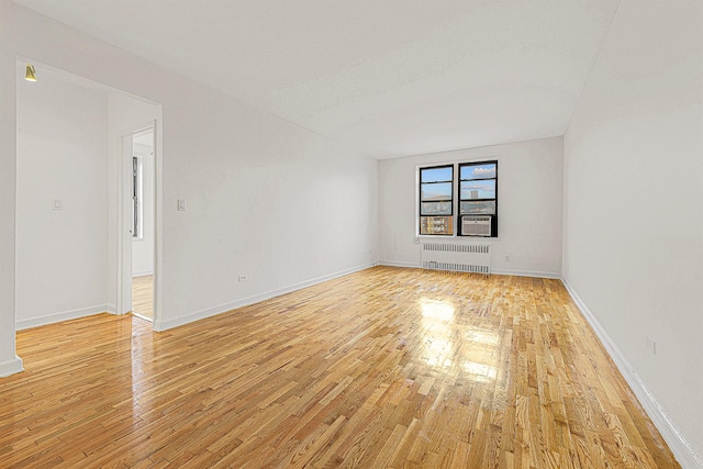 empty room featuring radiator and light wood-type flooring