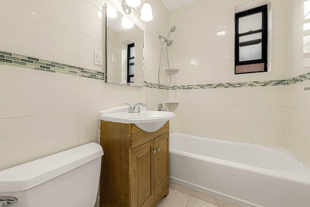 full bathroom with tile walls, tile patterned flooring, vanity, tiled shower / bath combo, and toilet