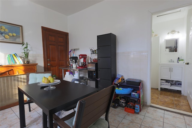 dining space featuring tile walls