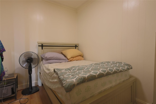 bedroom with crown molding and hardwood / wood-style flooring