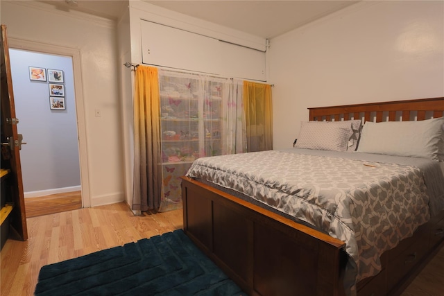 bedroom with hardwood / wood-style flooring and crown molding