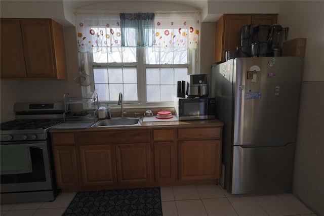 kitchen featuring sink, light tile patterned floors, and appliances with stainless steel finishes