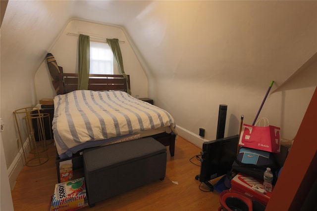 bedroom with lofted ceiling and hardwood / wood-style floors