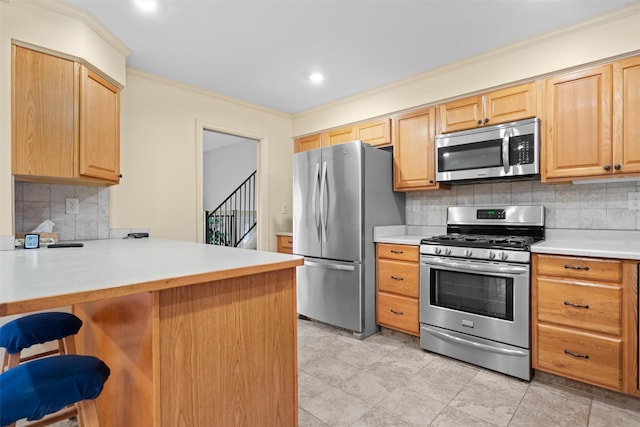 kitchen with appliances with stainless steel finishes, ornamental molding, a kitchen bar, decorative backsplash, and kitchen peninsula