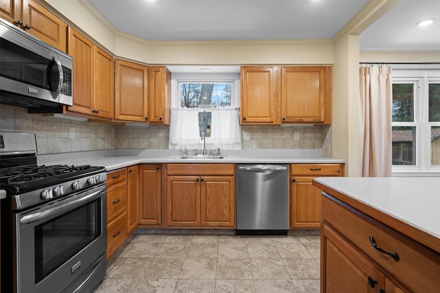 kitchen featuring sink, backsplash, ornamental molding, and appliances with stainless steel finishes