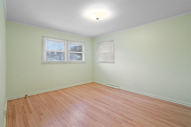 spare room featuring ornamental molding and light wood-type flooring