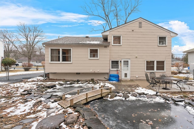 snow covered rear of property with a patio