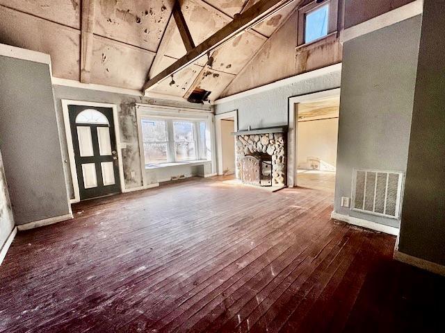 unfurnished living room with beam ceiling, a fireplace, high vaulted ceiling, and dark hardwood / wood-style floors