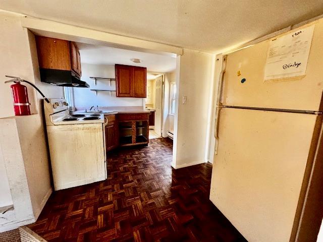 kitchen with white appliances and dark parquet flooring