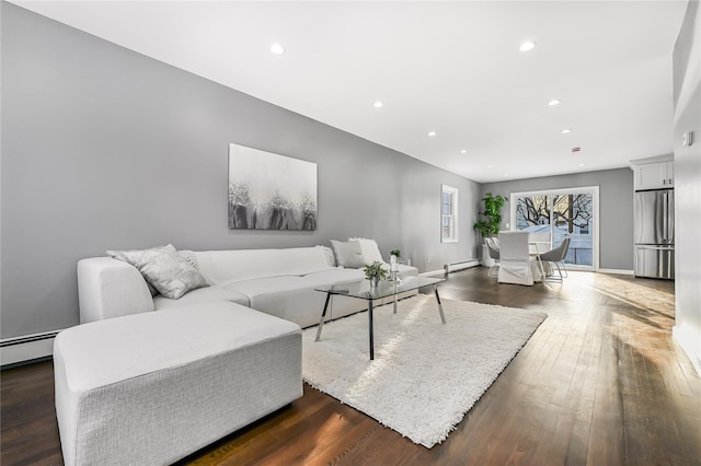 living room with dark hardwood / wood-style flooring and a baseboard heating unit