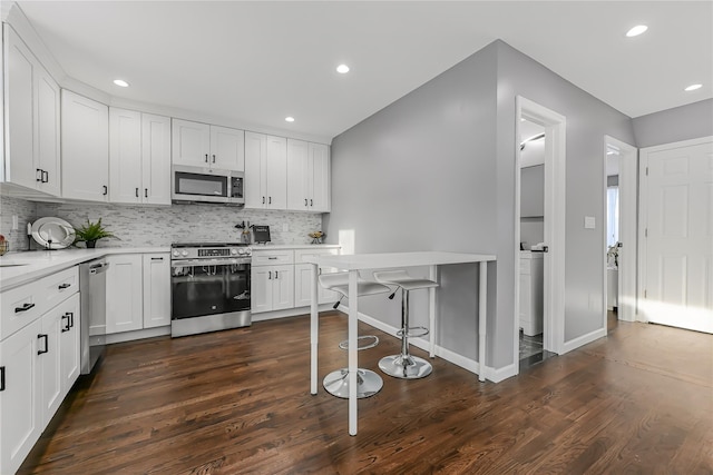 kitchen featuring tasteful backsplash, appliances with stainless steel finishes, dark hardwood / wood-style floors, and white cabinets