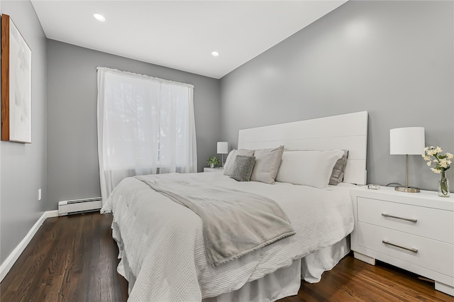 bedroom with a baseboard heating unit and dark wood-type flooring