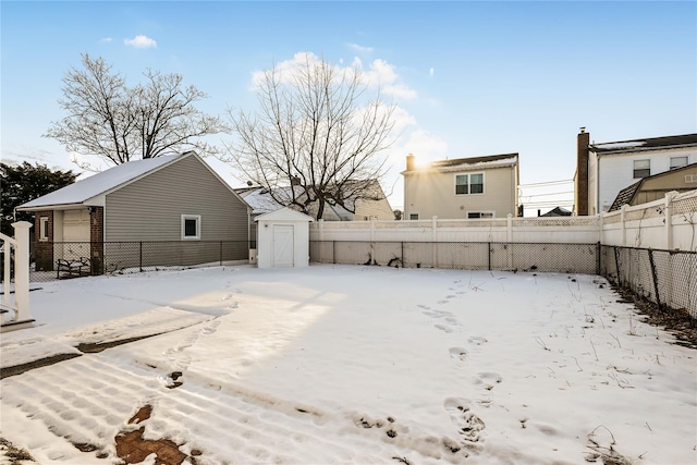 yard layered in snow featuring a storage shed