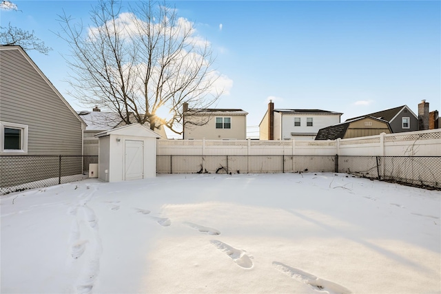 yard covered in snow featuring a storage unit