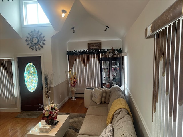 entryway featuring wood-type flooring, vaulted ceiling, and a baseboard radiator