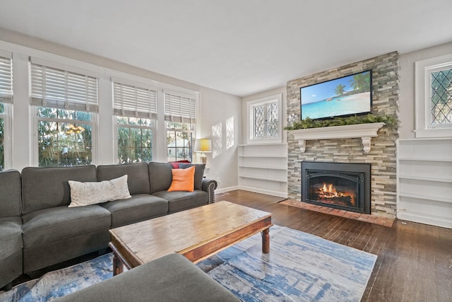 living room with dark hardwood / wood-style floors, a fireplace, and built in features