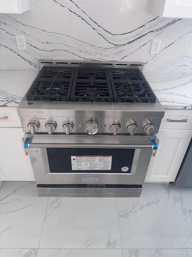 interior details with high end stainless steel range oven and white cabinetry