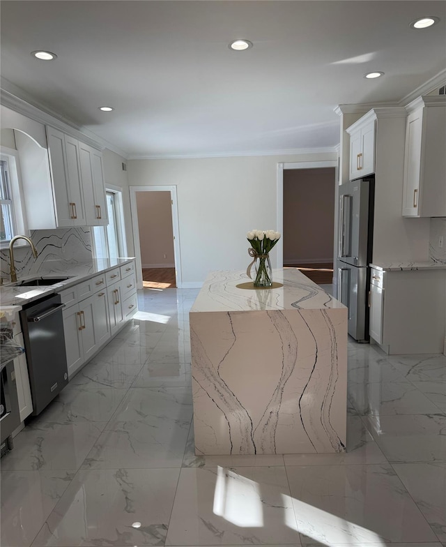 kitchen featuring sink, white cabinetry, a center island, stainless steel appliances, and light stone countertops