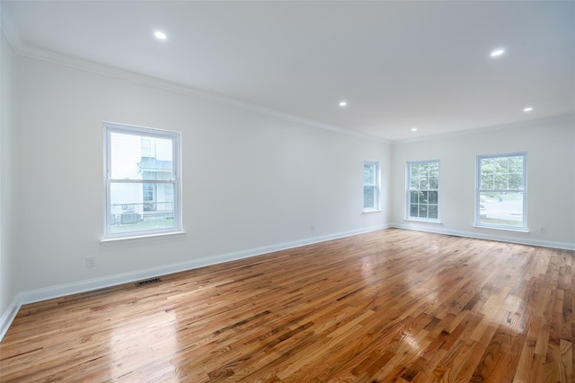 empty room featuring crown molding and light wood-type flooring