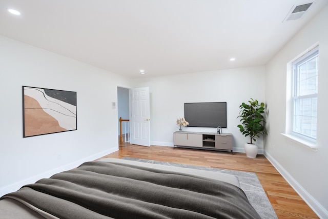 bedroom featuring multiple windows and light hardwood / wood-style floors