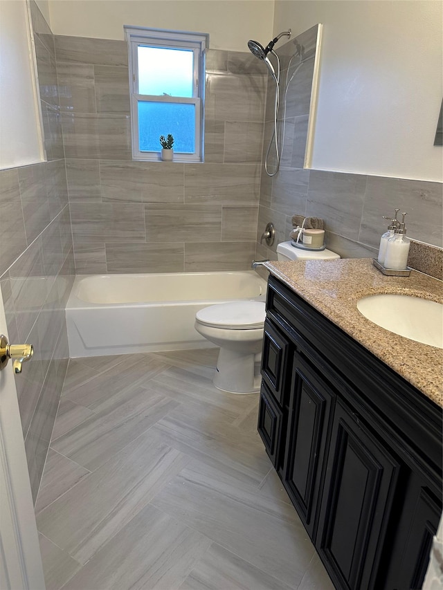 full bathroom featuring toilet, tile walls, vanity, tiled shower / bath combo, and tile patterned flooring