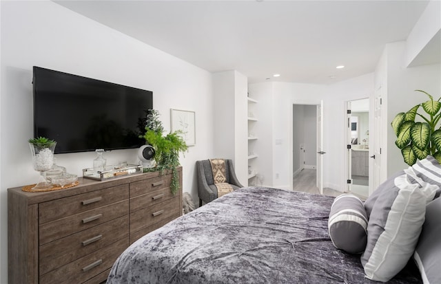 bedroom featuring ensuite bath and light hardwood / wood-style flooring