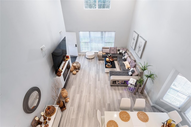 living room featuring light hardwood / wood-style floors and a high ceiling