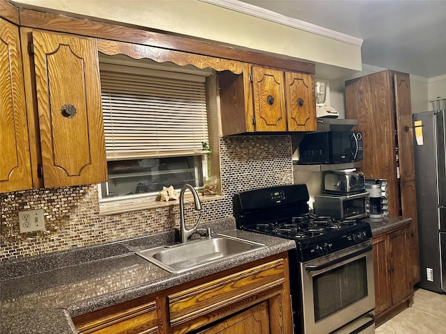 kitchen featuring sink, backsplash, light tile patterned floors, and appliances with stainless steel finishes