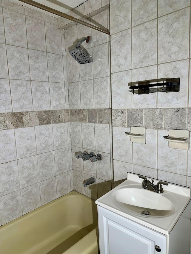 bathroom featuring tiled shower / bath and vanity