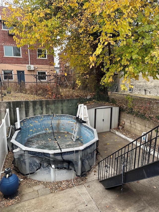 view of swimming pool with a storage unit