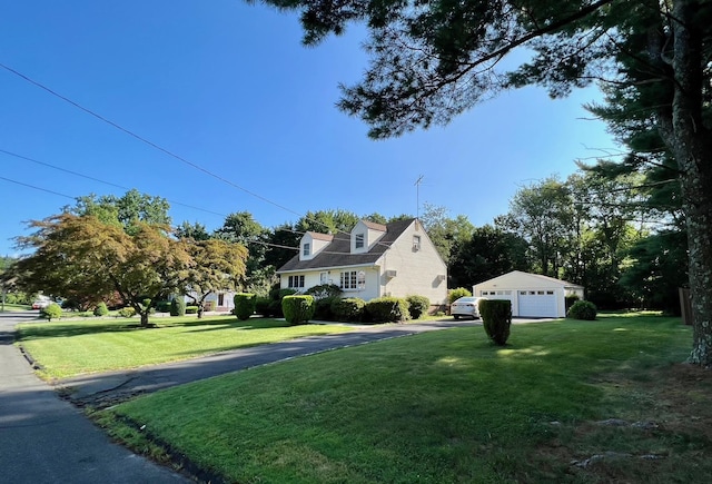 view of side of home featuring a garage, a lawn, and an outdoor structure