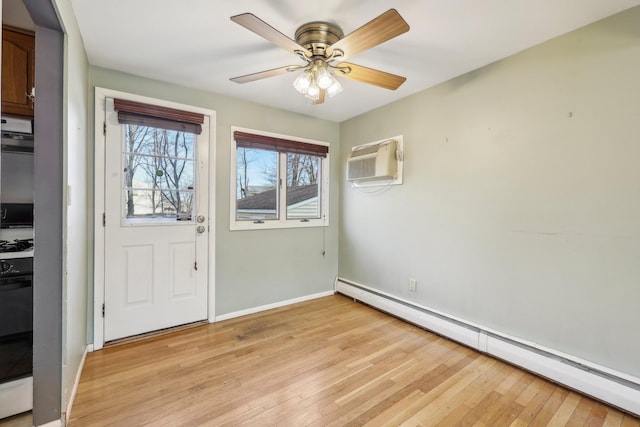 entrance foyer featuring a baseboard heating unit, a ceiling fan, baseboards, an AC wall unit, and light wood-type flooring