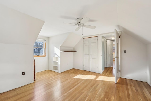 additional living space featuring vaulted ceiling, ceiling fan, and light wood-style flooring