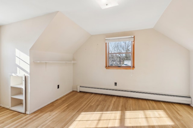 additional living space featuring a baseboard radiator, lofted ceiling, and wood finished floors