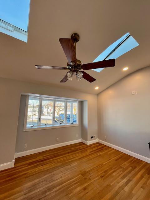 unfurnished room with hardwood / wood-style floors, plenty of natural light, and ceiling fan