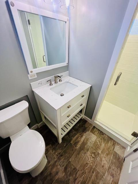 bathroom with vanity, toilet, and a shower with shower door