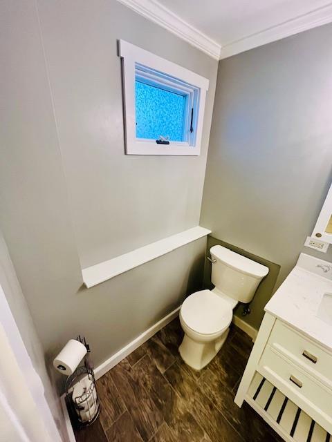 bathroom featuring crown molding, vanity, and toilet